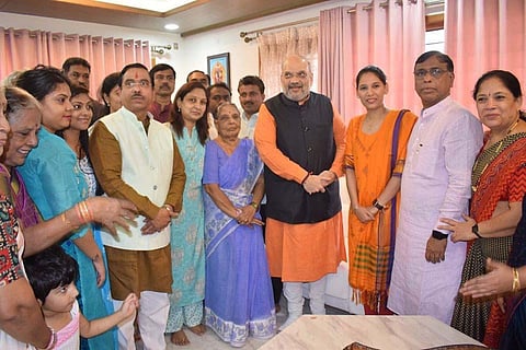 Union Home Minister Amit Shah, who was in the state over the weekend, poses with the family of Union Minister Pralhad Joshi and staff at the latter’s residence in Hubballi on Sunday.