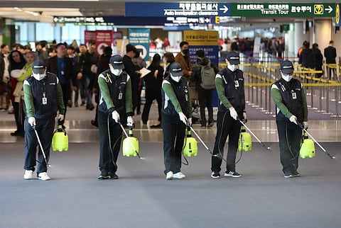 Workers from a cleaning service spray disinfectant at the customs, immigration and quarantine (CIQ) area at Incheon international airport, west of Seoul, on January 21, 2020. South Korea on January 20 confirmed its first case of the SARS-like virus that i