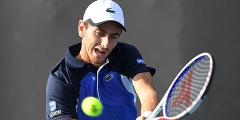 France's Elliot Benchetrit hits a return against Japan's Yuichi Sugita during their men's singles match on day two of the Australian Open tennis tournament in Melbourne. (Photo | AFP)
