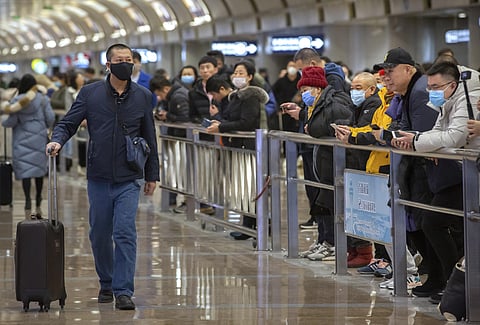 A traveler wearing a face mask walks into the arrivals area at Beijing Capital International Airport in Beijing. (Photo | AP)