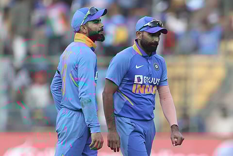 Indian skipper Virat Kohli (L) and Mohammed Shami leave the field at the end of Australian innings during the3rd ODI between India and Australia in Bangalore. (Photo| AP)