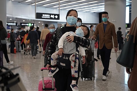Passengers wearing protective face masks enter the departure hall of a high speed train station in Hong Kong. (Photo| AP)