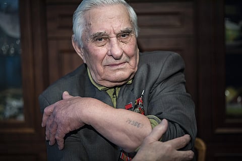 Yevgeny Kovalev, one of the Auschwitz concentration camp's survivors, shows the camp's identification number tattooed on his arm. (Photo | AP)
