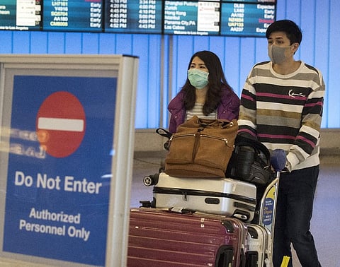 passengers wear protective masks to protect against the spread of the Coronavirus. (Photo| AFP)