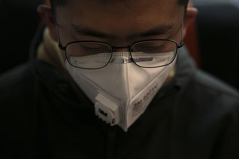 Post-coronavirus outbreak in China, a man wears a mask as he travels on a train.