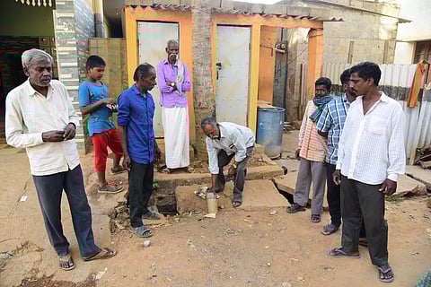 Narayanswamy, a manual scavenger, along with his fellow colleague, shows a pit which needs to be cleaned manually. (Photo| Vinod Kumar T, EPS)
