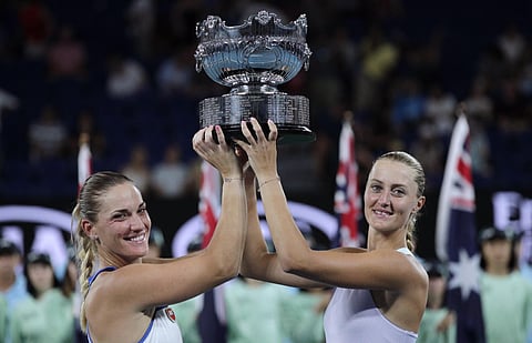 Hungary's Timea Babos (L) and France's Kristina Mladenovic hold the Australian Open women's doubles trophy. (Photo | AP)