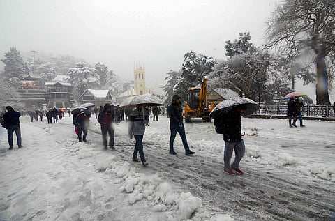 Tourists stroll at Ridge in Shimla during heavy snowfall (Photo | PTI)