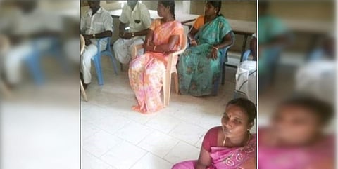 S Rajeswari (in pink) was sitting on the floor at a meeting and others were sitting on chairs. (Photo| Twitter)
