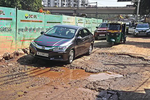 Vehicles crossing potholes on a busy Ashram road; (right) Akshardham Flyover is riddled with craters. (Photo | EPS/Parveen negi)