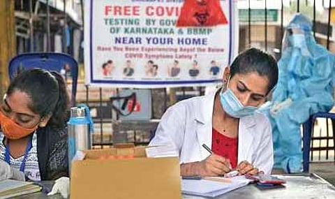 Health staffers at a fever clinic take down details of people for testing in Bengaluru | Meghana Sastry