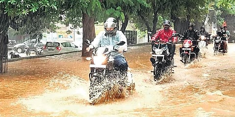 Commuters drive through an inundated road in Berhampur. (Photo | EPS)