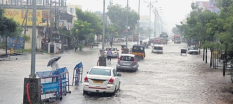 Vehicles wade through a waterlogged road in Warangal city.