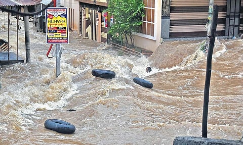 A man tries to hold on to a tyre to save himself from getting washed away in Falaknuma on Wednesday. He is yet to be traced | VINAY MADAPU