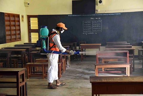 A cleanliness worker disinfects an exam paper evaluation centre at a school in Tirunelveli. (File Photo | V Karthikalagu, EPS)