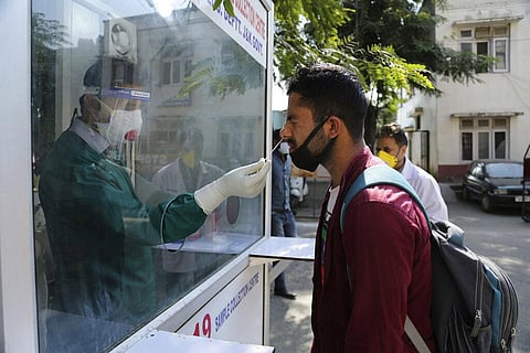 A health worker collects a nasal swab sample to test for COVID-19 at a government hospital in Jammu, India, Saturday, Oct. 17, 2020. (Photo | AP)