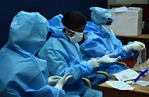 Healthcare workers getting ready by donning personal protective equipment (PPE) before testing swabs. (Photo| EPS/ U Rakesh Kumar)