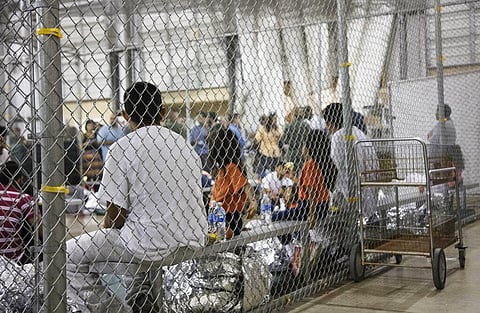 People who've been taken into custody related to cases of illegal entry into the United States, sit in one of the cages at a facility in Texas in 2018. (Photo | AP)