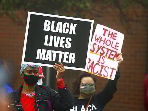 People hold signs during a protest rally for Marcellis Stinnette who was killed by Waukegan Police last Tuesday in Waukegan, Ill., Thursday, Oct. 22, 2020. (Photo | AP)