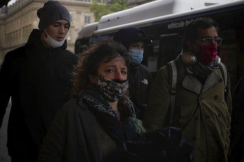 People wear masks as they walk in a street of Paris, Tuesday, Oct. 27, 2020. (Photo | AP)