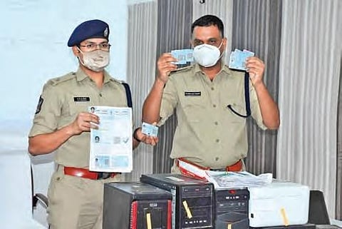 Kurnool SP K Fakeerappa displaying the fake Aadhaar and PAN cards before the media at the District Police Office in Kurnool I Express