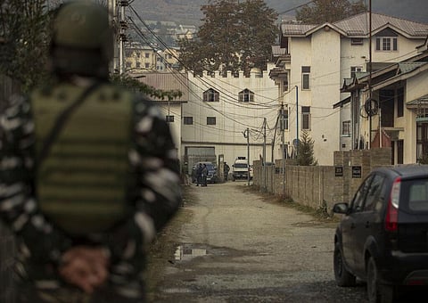 An Indian paramilitary soldier stands guard as NIA personnel search the premises of AFP’s Kashmir correspondent Parvaiz Bukhari on the outskirts of Srinagar. (Photo | AP)