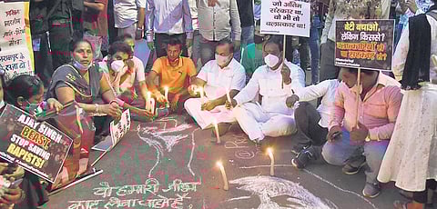 People light candles during a protest demanding justice for the Hathras case victim