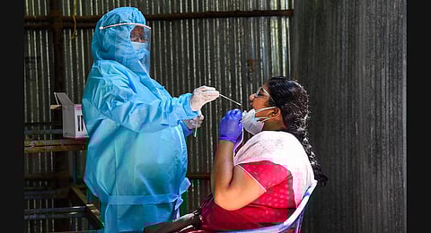 A health worker collects swab samples from a woman to test for Covid19 at a fever camp in Tiruchy. (Photo | M K Ashok Kumar, EPS)