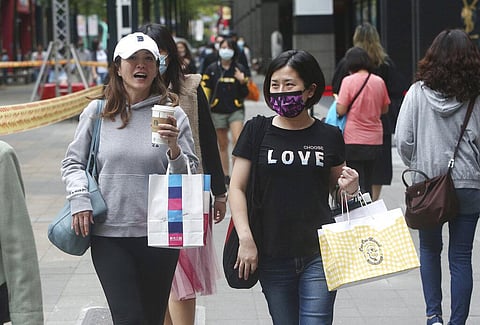 People wear face masks to protect against the spread of the coronavirus as they walk through a shopping district in Taipei, Taiwan. (Photo | AP)