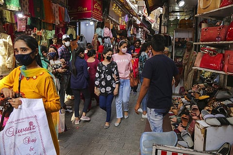 People wearing masks as a precaution against the coronavirus shop at a market. (File Photo | AP)
