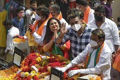 Sandalwood actors Amulya and Darshan greet voters during a roadshow for BJP’s RR Nagar candidate N Muniratna, in Bengaluru on Friday. (Photo| Meghana Sastry, EPS)