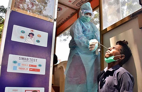 Health worker collects nasal swabs for Covid-19 from inside a sample collection unit. (Photo | U Rakesh Kumar, EPS)