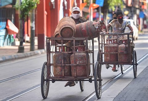 Workers carrying LPG cylinders on carts on their way to deliver them to consumers during Unlock 4 in Kolkata. (Photo | PTI)