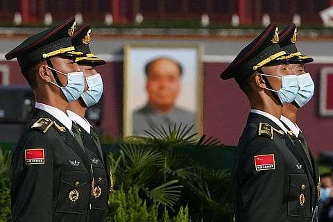 Chinese honor guards wearing masks to protect agains the coronavirus are seen near the portrait of late leader Mao Zedong during a ceremony held at the Monument to the People's Heroes. (Photo | AP)