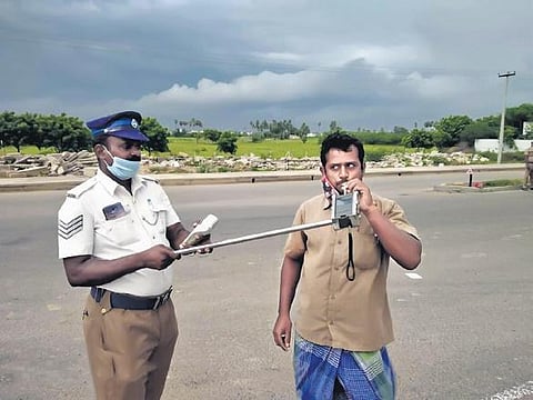 The Chennai City police testing a driver for drunken driving, taking into serious consideration the practice of physical distancing during the pandemic times
