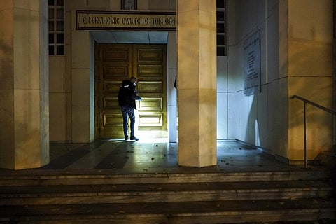 A police officer searches for clues after a priest was shot, Saturday (Photo | AP)