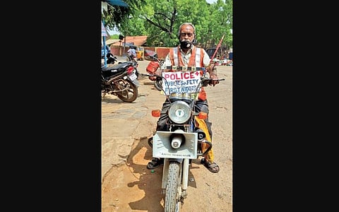 D Srinivasa Prasad on his motorcycle with the public safety and first-aid sign board. | Express