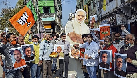 BJP worker celebrate the NDA's lead in Bihar Assembly elections and party's lead in UP Assembly bypolls, in Varanasi. (Photo | PTI)