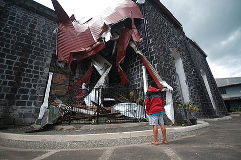 A man stands outside the typhoon-damaged St. John the Baptist church in Tabaco, Albay province, central Philippines last week. (Photo | AP)