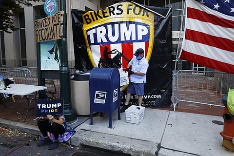 A postal worker collects mail inside the protest pen, as a handful of supporters of President Donald Trump continue to demonstrate, in Philadelphia. (Photo | AP)