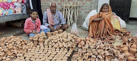 A potter family waits for customers to sell earthen lamps and other items ahead of the Diwali festival in Begusarai district Thursday. (Photo | PTI)