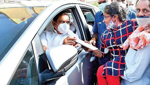 Chief Minister Edappadi K Palaniswami giving away a letter offering job to Marieswari, a physically disabled woman, in Thoothukudi on Wednesday