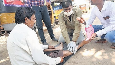 An auto rikshaw driver helping out a man.