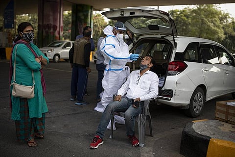 A health worker takes a nasal swab sample of a man to test for COVID-19 during random testing of people at the Delhi-Noida border on the outskirts of New Delhi, India. (Photo | AP)