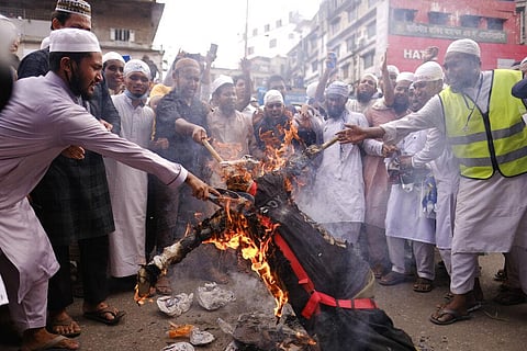 Bangladeshi Muslims protesting the French president’s support of secular laws allowing caricatures of the Prophet Muhammad march burn an effigy of Emmanuel Macron in Dhaka. (Photo | AP)