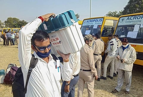 Polling officials carry Electronic Voting Machines EVMs on the eve of by-polls in Indore Monday Nov. 2 2020. (Photo | PTI)