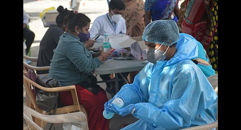 Health workers and technicians take a break between swab collection in Bengaluru on Thursday | Meghana Sastry