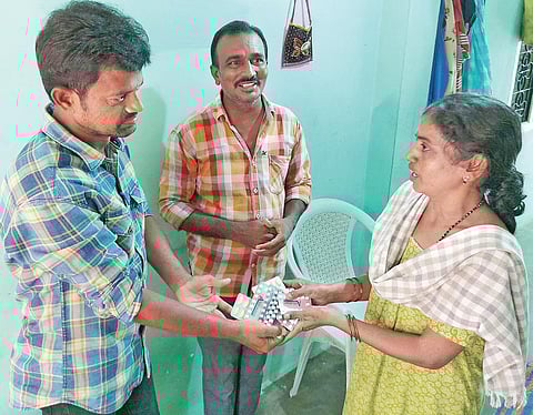 Venjeti Venkataramana Reddy donates medicines to a woman in Anantapur. (Photo | EPS)