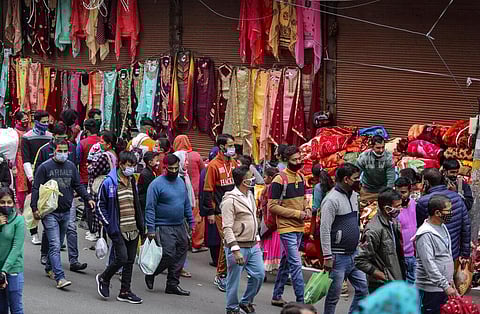 Indians, most of them, wearing face masks as a precautionary measure against the coronavirus crowd a Sunday market in Jammu. (Photo | AP)