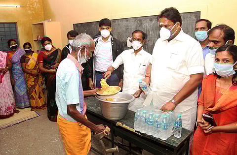 Tamil Nadu HR&CE Minister Sevoor S Ramachandran distributing food to evacuees at a temporary shelter in Kalasapakkam. (Photo| EPS)
